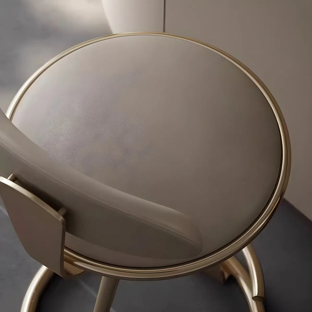 Luksusowy hoker z eleganckim beżowym siedziskiem ze skóry i złotym metalowym stelażem
